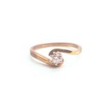 A 9ct yellow gold and solitaire diamond crossover ring, set with a round-cut diamond of