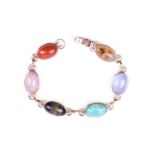 A yellow metal and hardstone bracelet, set with rose quartz, cats eye, and jadeite segments, the