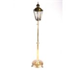 An early 20th century polished brass standard lamp in the form of a street lantern, the lamp of