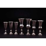 A set of three silver tots, 8.4 cm high, together with two similar pairs, the largest 11 cm, various