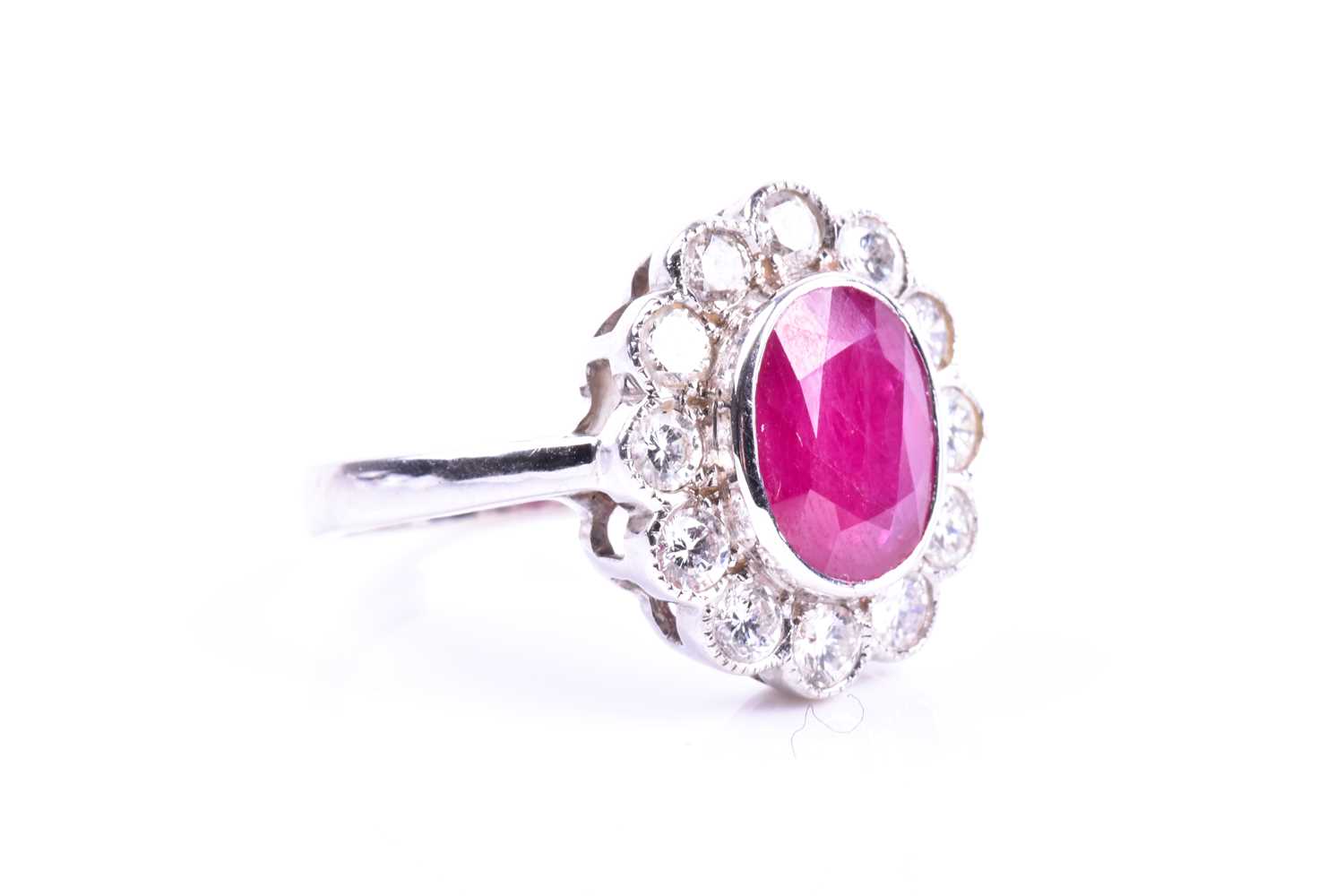 An 18ct white gold, diamond, and ruby cluster ring, set with a mixed oval-cut ruby of - Image 4 of 4