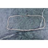 A graduated cultured pearl necklace, the white pearls measuring approximately 3-6 mm, fastened