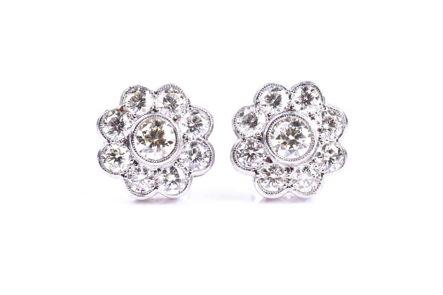 A pair of diamond floral cluster earrings, set with round brilliant-cut diamonds of approximately