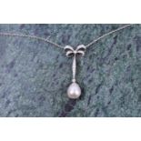 A diamond and pearl drop pendant necklace, the diamond-set bow-shaped mount suspended with a
