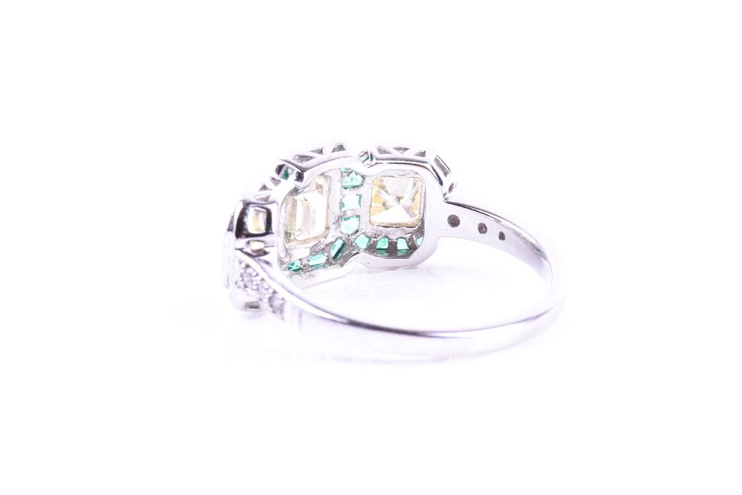 A diamond and emerald ring, set with an emerald-cut diamond flanked with two mixed square-cut - Image 3 of 5