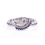 A white metal, diamond, and sapphire bracelet, the swept central segment set with round brilliant-