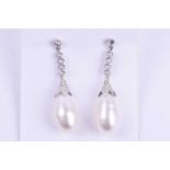 A pair of diamond and pearl drop earrings, each with an elongated cultured pearl, set in a diamond-