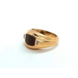 A 14ct yellow gold and black onyx signet ring, with faceted dome onyx inset between two diamond