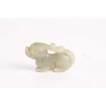 A Chinese jade stag, Ming dynasty, in a recumbent pose, the stone a grey/green colour,