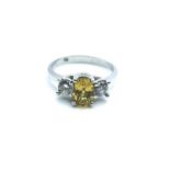 An 18ct white gold, diamond, and yellow sapphire, set with a mixed oval-cut sapphire, flanked with