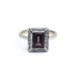A 9ct yellow gold, diamond, and garnet ring, set with a mixed rectangular-cut garnet, within a