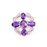 A diamond and amethyst brooch, set with four mixed oval-cut amethysts in a cross design, with four