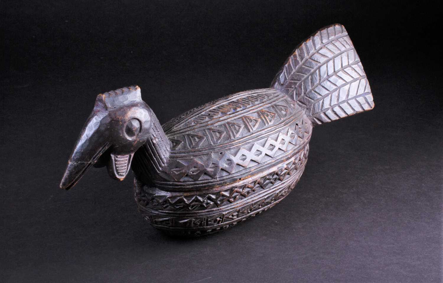 A Yoruba carved wood box in the form of a bird, Nigeria, with chip carved geometric band decoration,