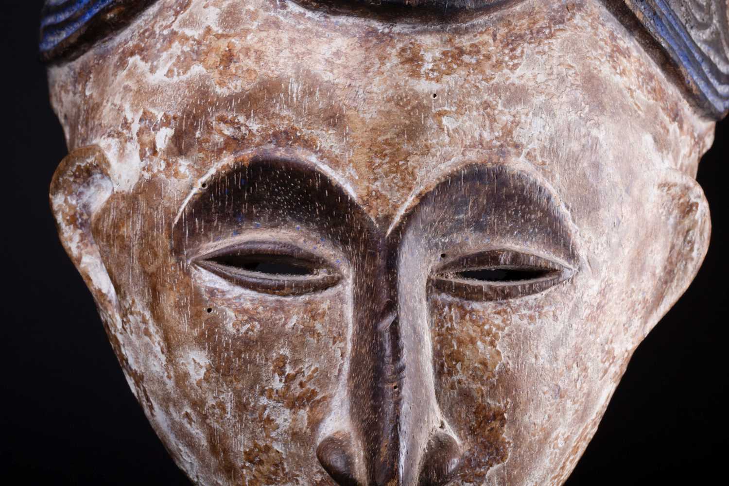 An Igbo Maiden Spirit mask, Nigeria, in red, blue and white pigment, the edges pierced with holes, - Image 3 of 6