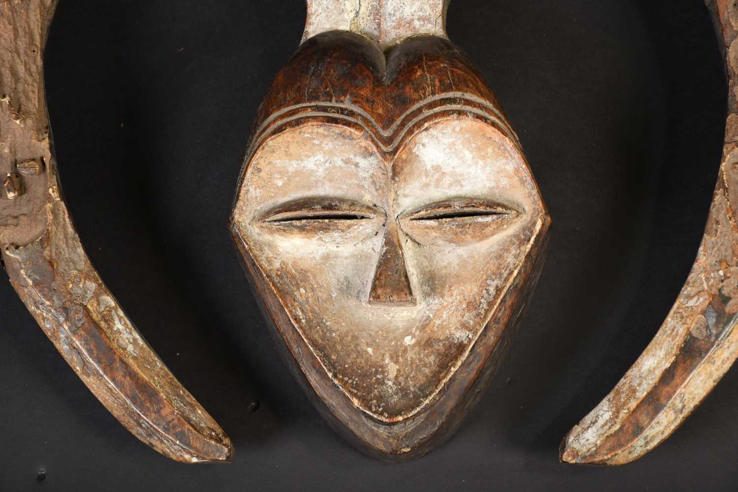 A Kwele mask, Gabon, the mask with narrow eye slits, a small mouth showing teeth and incised lines - Image 2 of 4