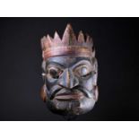 An Indonesian carved and painted ceremonial male mask, in yellow, red, white and black pigment,