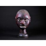 An Ejagham (Ekoi) leather bound carved wood headpiece, the head with applied hair, the maroon