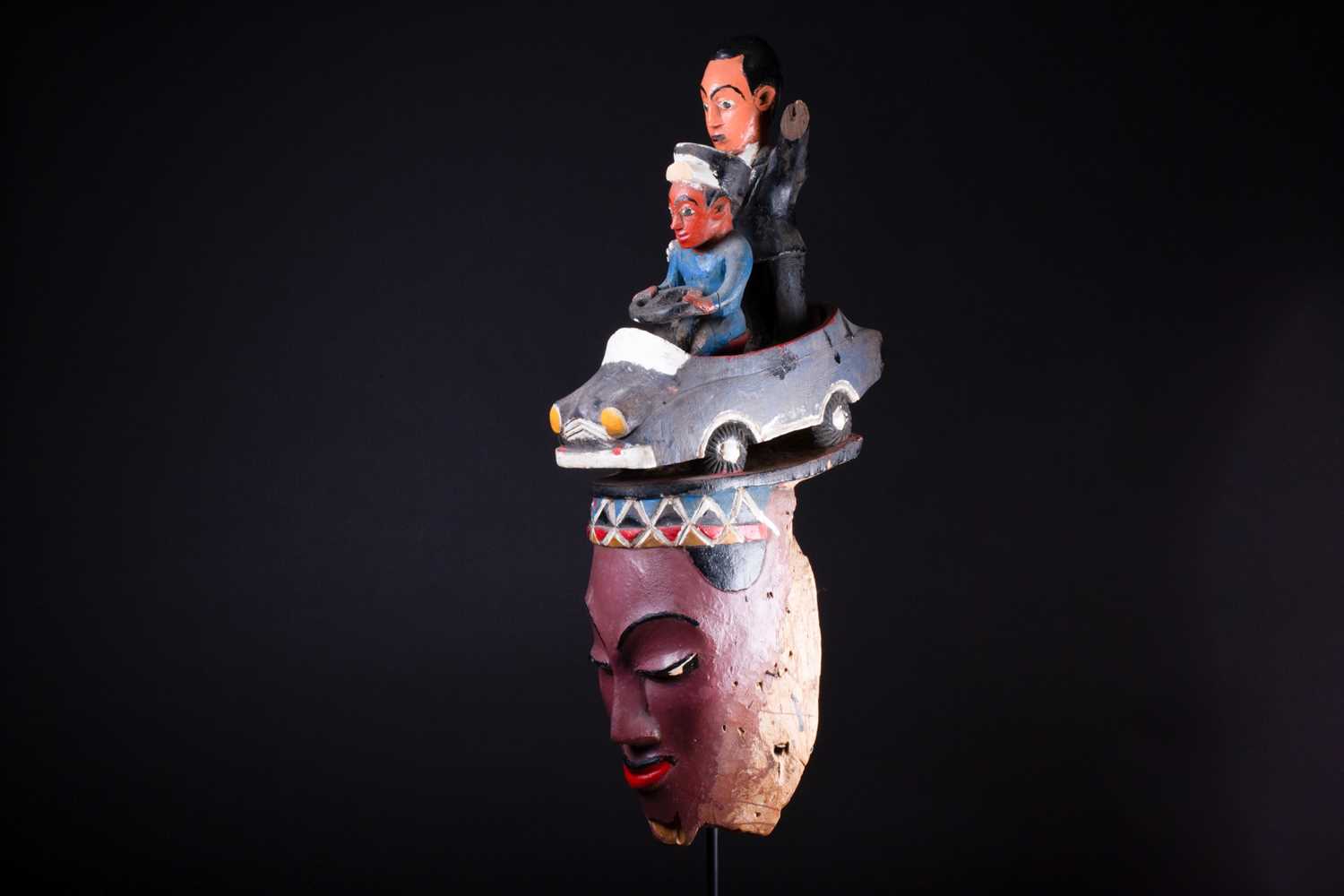 A Colon mask, Nigeria, the female mask painted in polychrome, surmounted by a car with a standing - Image 6 of 7