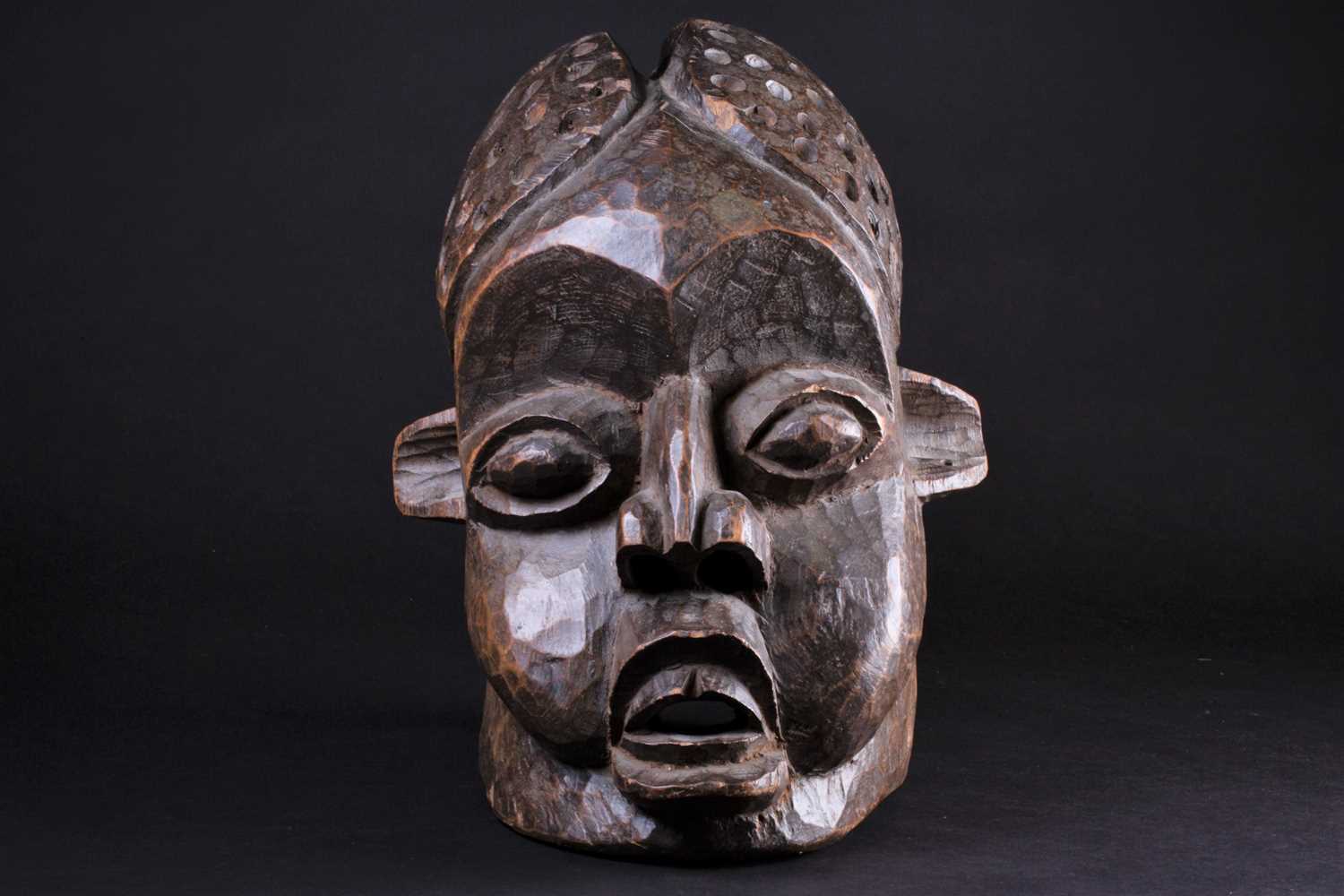 A Bamileke helmet mask, Cameroon, an elliptical opening to the crown of the elongated head, with