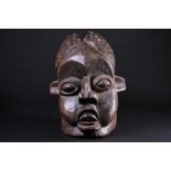 A Bamileke helmet mask, Cameroon, an elliptical opening to the crown of the elongated head, with