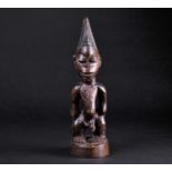 A Yoruba Ibeji standing male figure, his chest and back with carved Tirah, the geometric carved