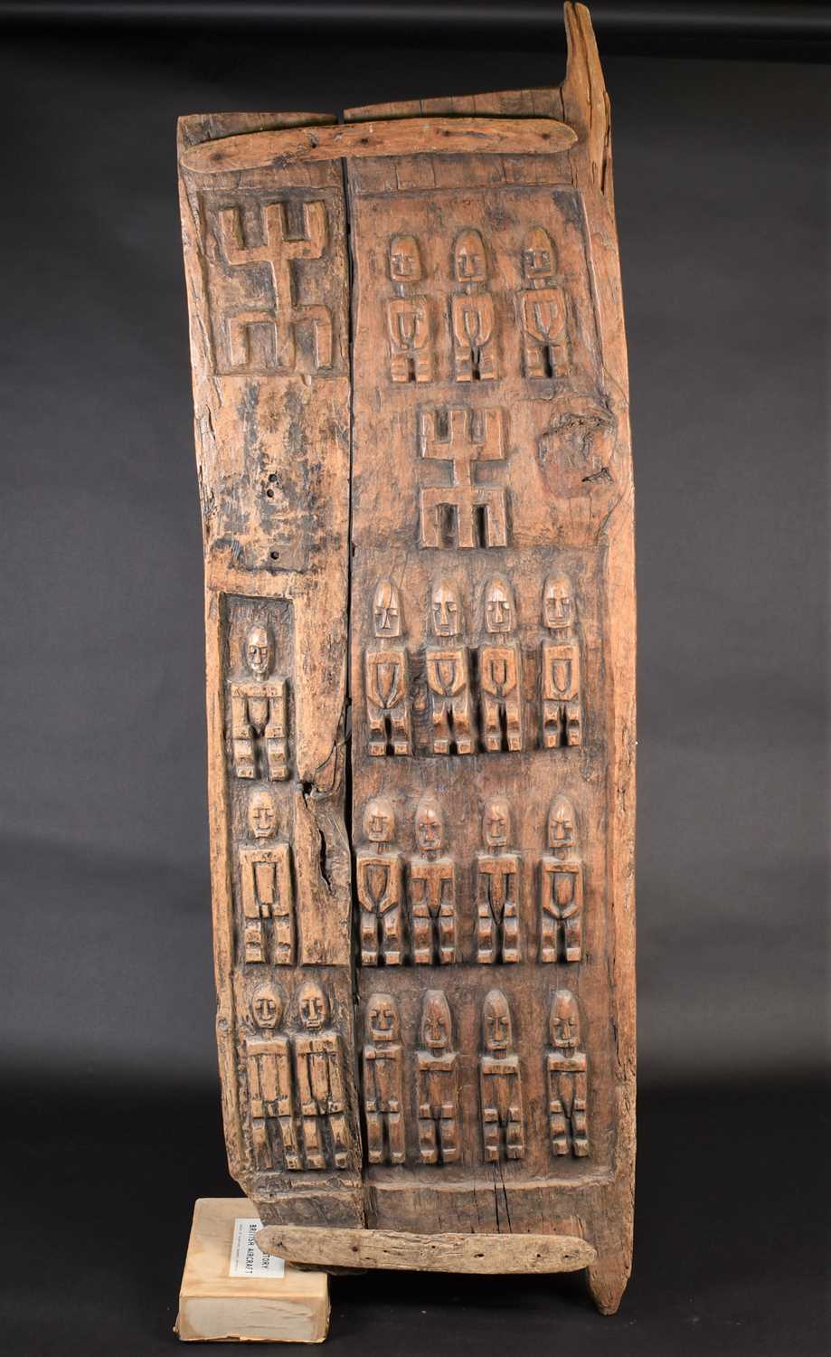 A Dogon carved wood door, Mali, carved with ancestral figures, 159cm x 56cm (excluding housing