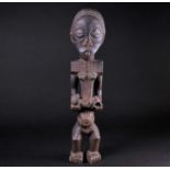 A carved wood Bembe standing maternity figure, Democratic Republic of Congo, with carved braided