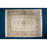 A 20th century Qum rug, silk on silk rug, the central polylobate boss on a subtle ivory ground of