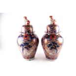 A pair of large Arita imari vases and covers, mid 19th century, each baluster body densely decorated