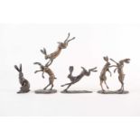 A bronze figure of boxing hares by Paul Jenkins, signed to the base, 11cm, together with three