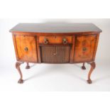 A George III style mahogany bow fronted kneehole and tambour sideboard, with ebony strung and