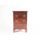 A small Geo III style mahogany chest of three short drawers with brushing slide above. Raised on