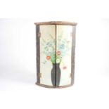 A Geo III two-door hanging cylinder corner cupboard now hand-painted corner cupboard by Jean de