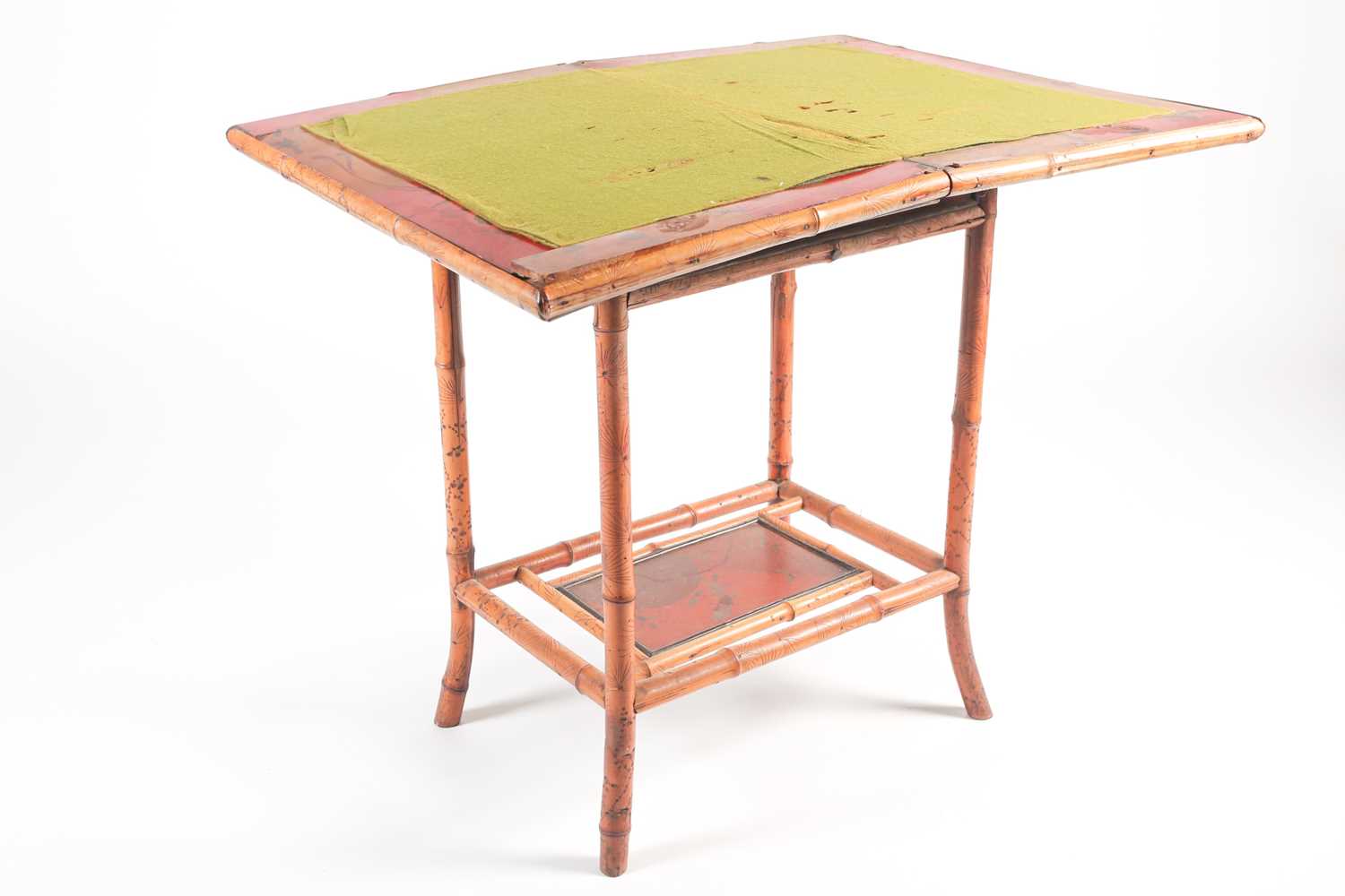 A 19th century bamboo and painted lacquer fold-over gaming table with under tier. Raised on slightly