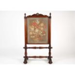 A Victorian mahogany and petit point firescreen, with shell and scroll decoration over turned