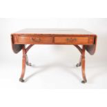 A George IV figured mahogany sofa table with radiused fly leaves and fitted two actual and two