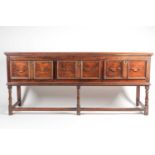 A Charles II style oak dresser base with three molded frieze drawers. Raised on turned supports