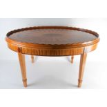 A good quality, oval Sheraton style, satinwood, low table with a crossbanded and strung, harewood