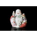A Chinese 20th century Famille rose, porcelain figure of the corpulent, seated Hotei with red-
