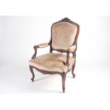 A French Louis XV style carved walnut fauteuil with stuff over back and seat. Raised on shaped