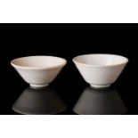 A near pair of 19th/20th century, Chinese turned ivory wine cups of footed, plain conical form.