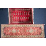 A 20th century Indian carpet runner with cruciform lozenges on a plum red ground within multiple