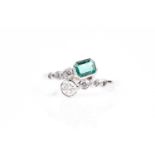 An emerald and diamond crossover ring, with rectangular cut-cornered step-cut emerald and