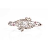 A late Victorian diamond and ruby bangle, the principle old brilliant-cut diamond within a halo