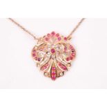 An Indian yellow metal pendant, the openwork mount inset with rubies and white paste stones,