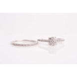 A silver and diamond cluster engagement style ring, set with small round-cut diamonds, cluster