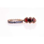 A three stone half hoop garnet ring, the graduated oval garnets in ornate carved 9ct yellow gold