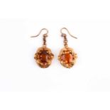 A pair of yellow metal and citrine earrings, each set with a mixed oval-cut citrine within a