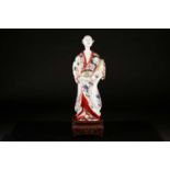 A Japanese Edo period porcelain figure of a Bijin with tied hair and wearing a floral and fan