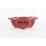 A Chinese cinnabar lacquer bowl, of shaped oval form, with floral decorated reserves, 10 cm high x